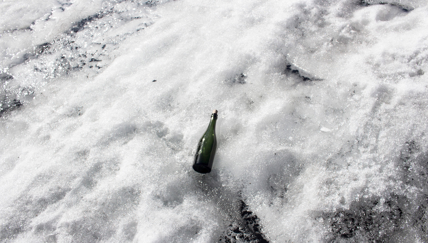 Flasche liegt im Schnee des Gletschers