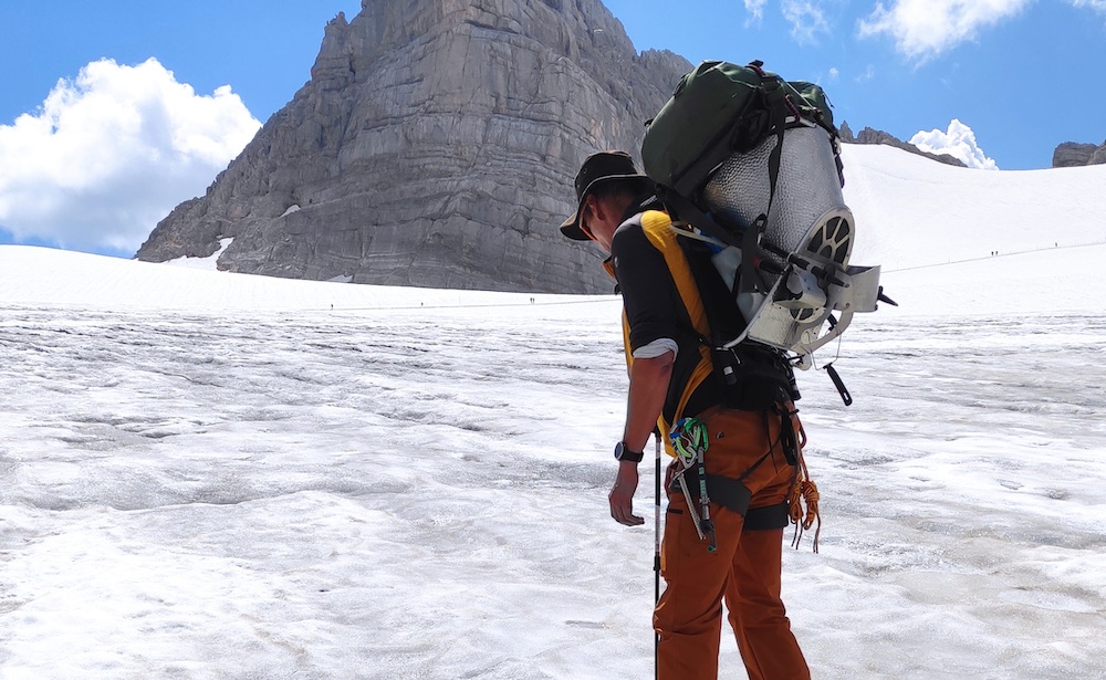 Person mit Forschungsausrüstung auf dem Hallstätter Gletscher im Dachsteinmassiv.